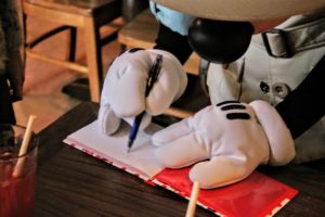 Mickey autografando caderninho no Tusker House