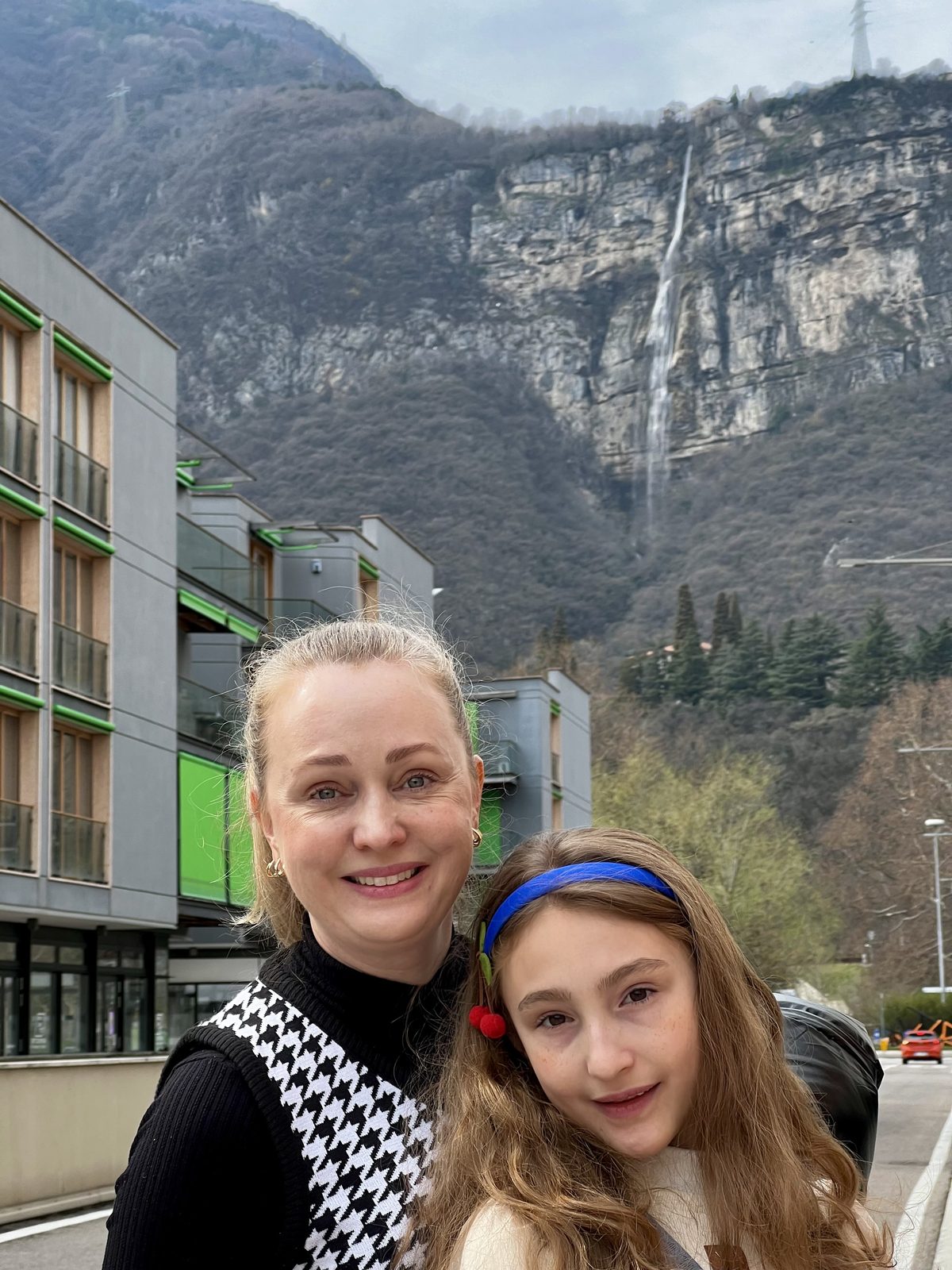 Paty e Martina com a cascata na montanha vista do MUSE em Trento