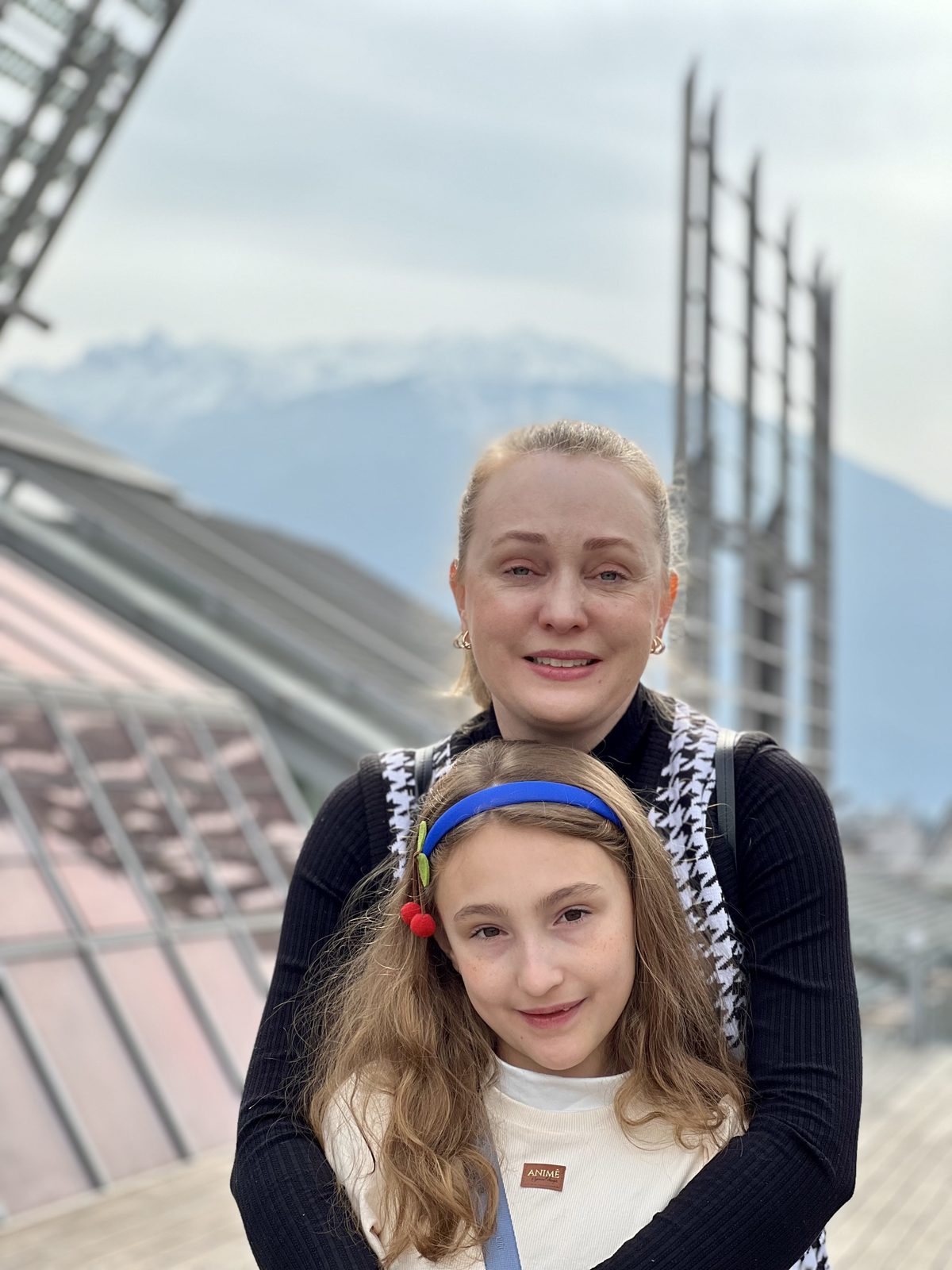 Paty e Martina no terraço do MUSE com o telhado projetado por Renzo Piano e montanhas ao fundo